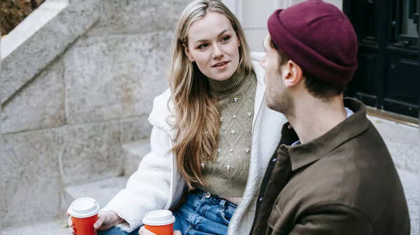 Woman looking thoughtful while her partner is on his phone.